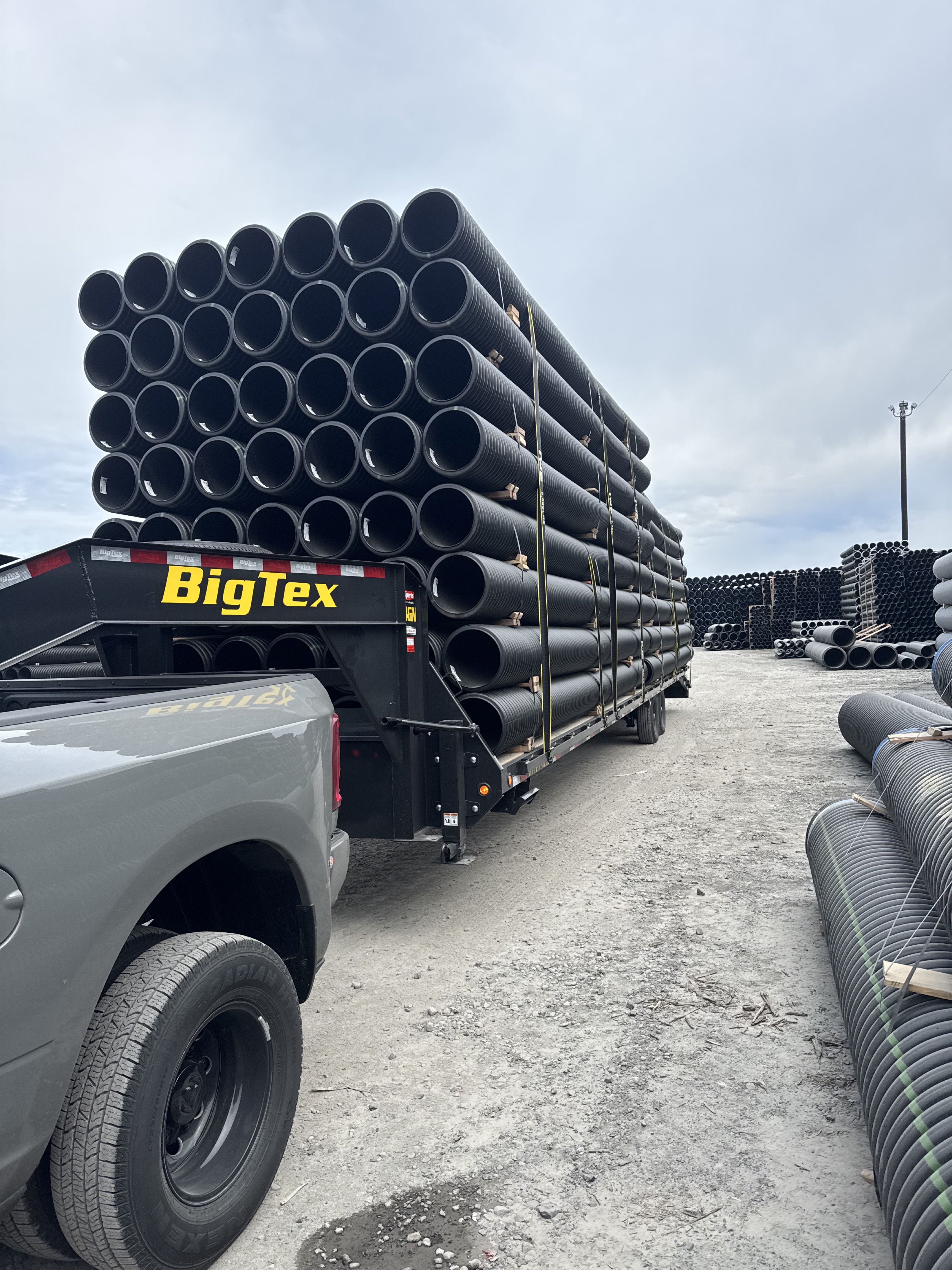 Truck and gooseneck trailer hauling large pipe